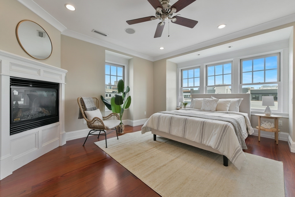 111 Bolton Street, Unit 2 Boston, MA 02127 - Photo 25 of 36 a spacious bedroom with a bed a window and a chandelier