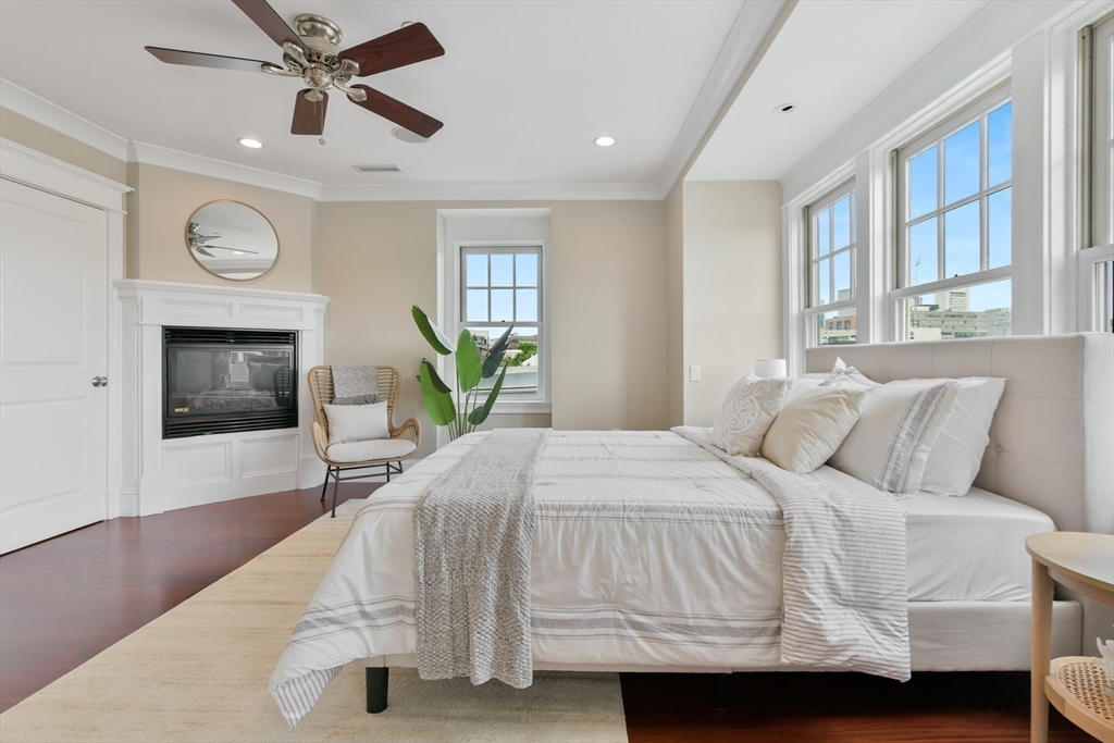 111 Bolton Street, Unit 2 Boston, MA 02127 - Photo 27 of 36 a bedroom with a bed a fireplace and a window