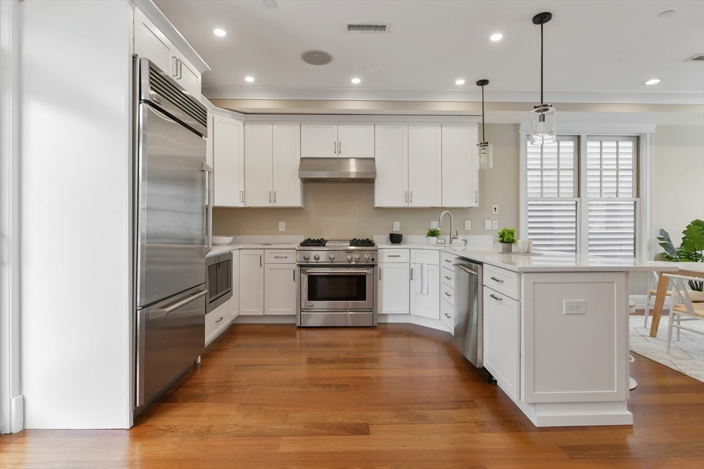 111 Bolton Street, Unit 2 Boston, MA 02127 - Photo 4 of 36 a kitchen with granite countertop a refrigerator oven a sink and white cabinets