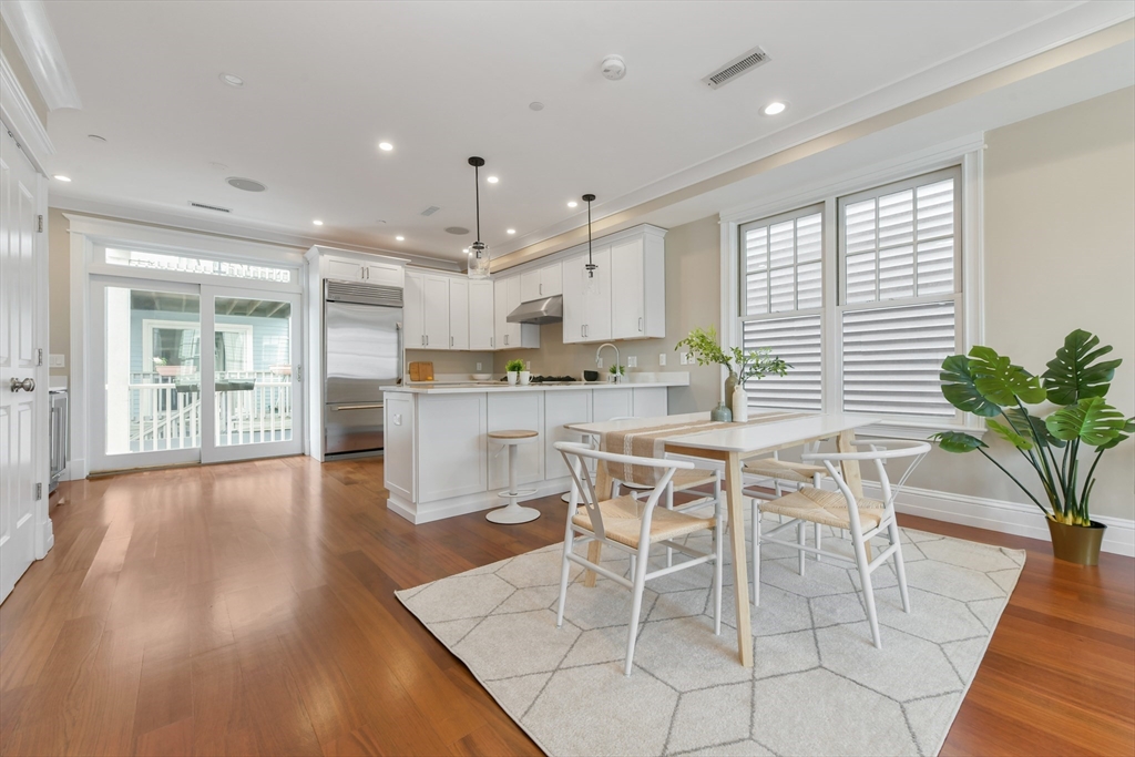 111 Bolton Street, Unit 2 Boston, MA 02127 - Photo 7 of 36 a dining room with stainless steel appliances kitchen island granite countertop wooden floor a dining table and chairs
