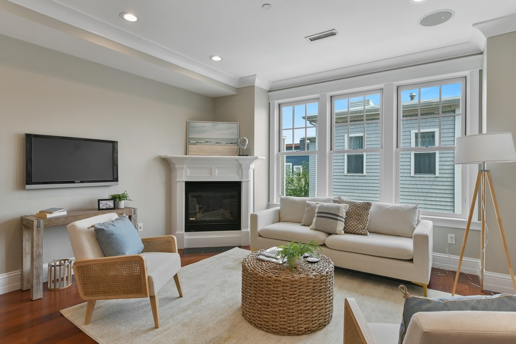 111 Bolton Street, Unit 2 Boston, MA 02127 - Photo 9 of 36 a living room with furniture a flat screen tv and a fireplace