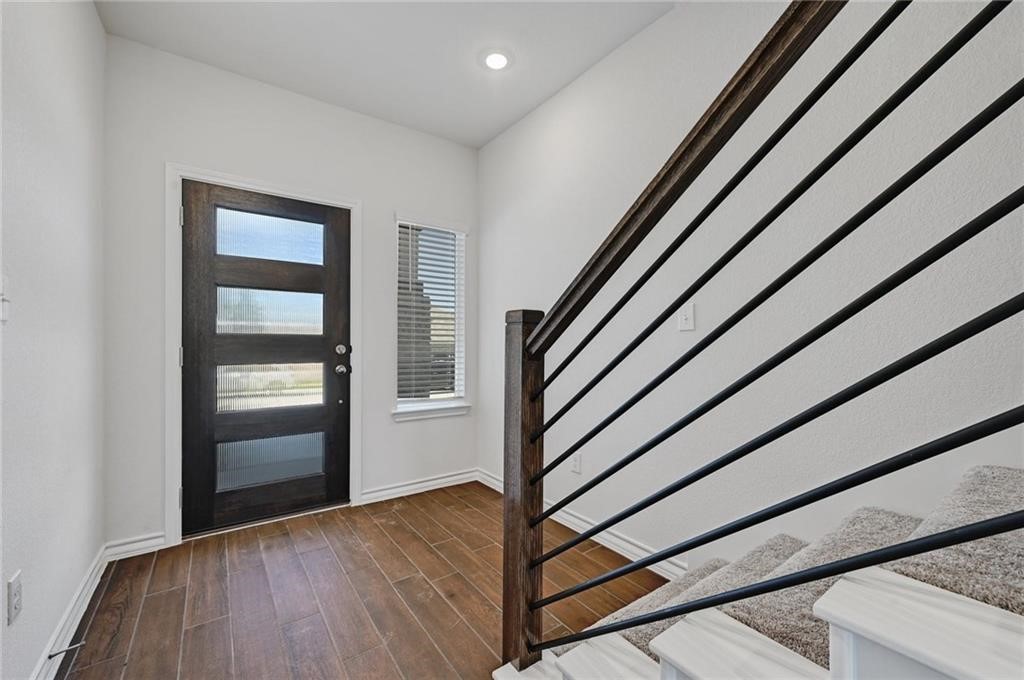 806 Pepperbark Loop Buda, TX 78610 - Photo 4 of 39 a view of a hallway with wooden floor and stairs
