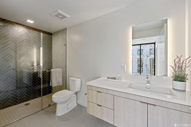 a bathroom with a double vanity sink toilet and shower