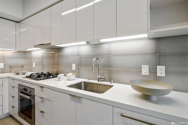 a kitchen with a sink a stove and cabinets