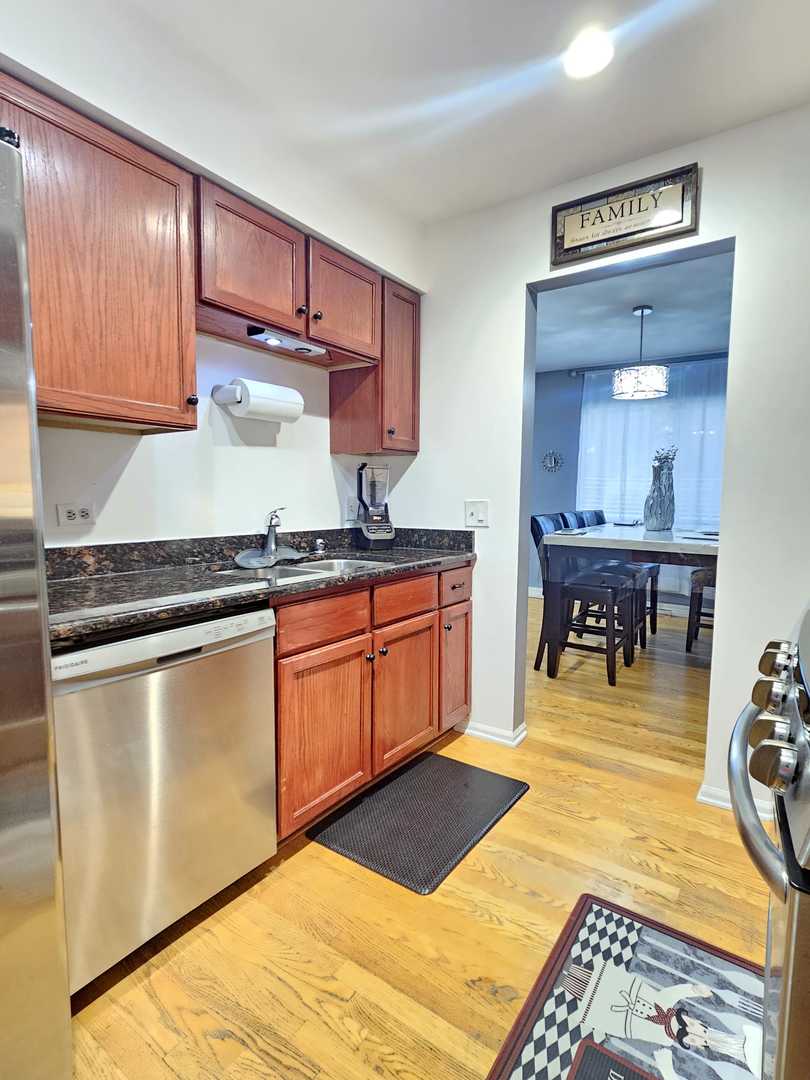 441 Commanche Trail Wheeling, IL 60090 - Photo 6 of 26 a kitchen with stainless steel appliances granite countertop a sink dishwasher stove and cabinets