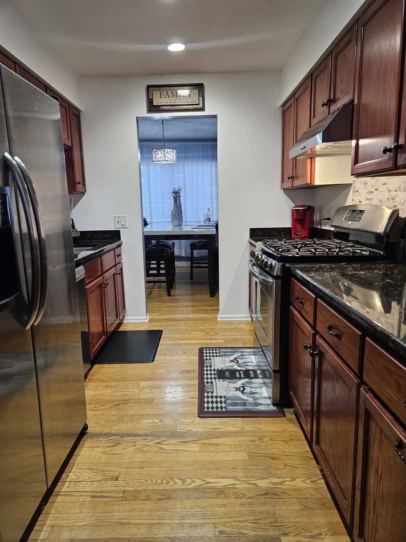 441 Commanche Trail Wheeling, IL 60090 - Photo 7 of 26 a kitchen with stainless steel appliances granite countertop a stove a sink and a refrigerator