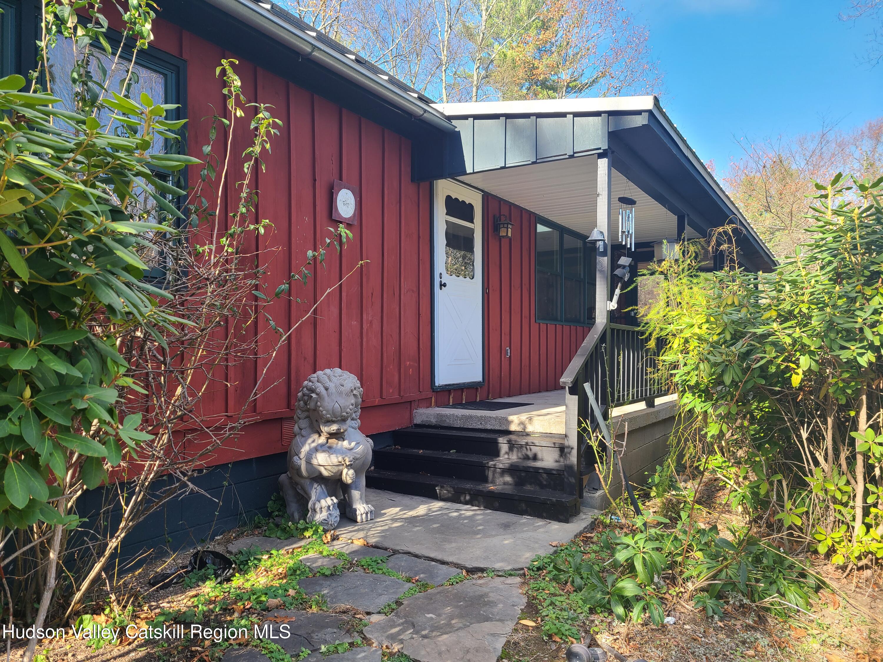 a backyard of a house with potted plants and large tree