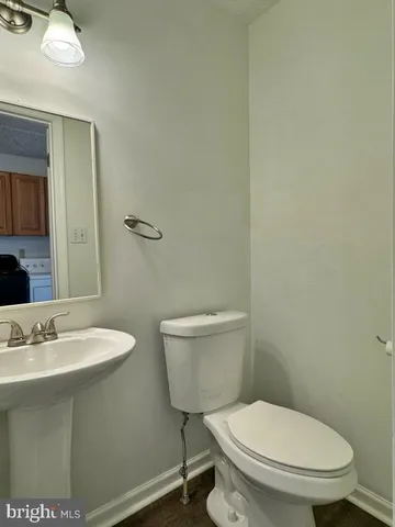 a bathroom with a toilet a sink and mirror