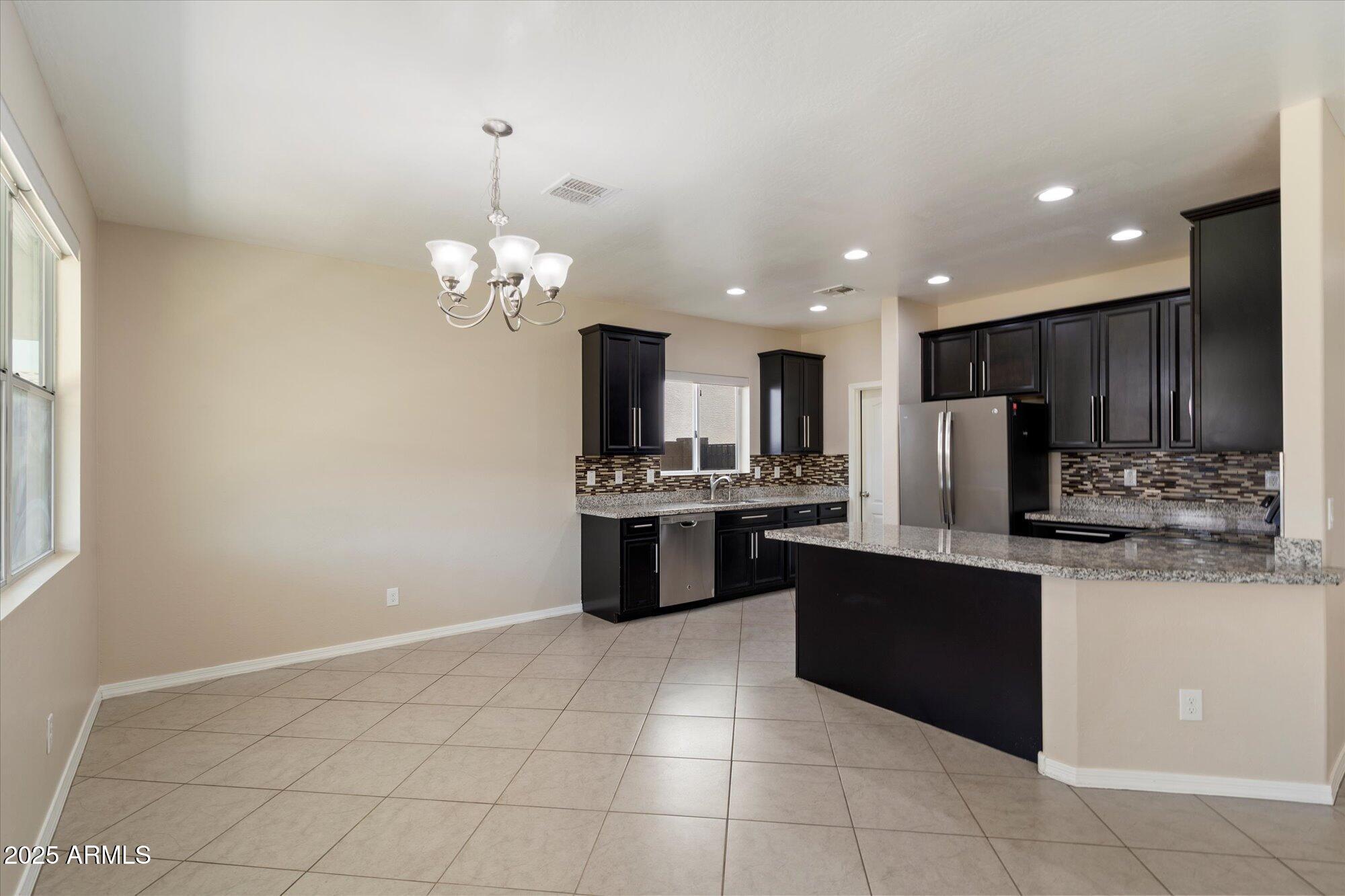 737 East Harwell Road Phoenix, AZ 85042 - Photo 10 of 28 a kitchen with kitchen island granite countertop stainless steel appliances cabinets a sink and a counter top