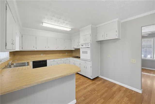 a kitchen with granite countertop white cabinets and white appliances