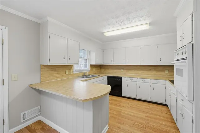 a kitchen with granite countertop white cabinets and white appliances