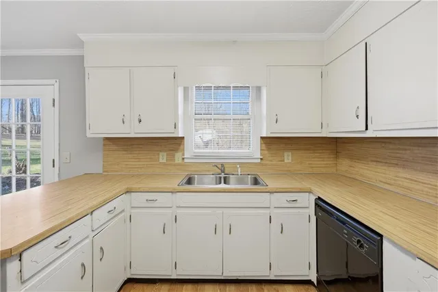 a kitchen with white cabinets and a sink