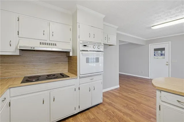a kitchen with white cabinets and white appliances