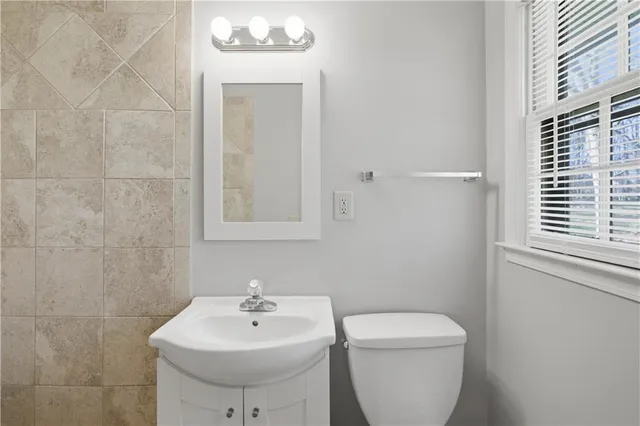 a bathroom with a sink toilet and mirror