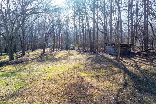 a backyard of a house with barbeque oven and trees
