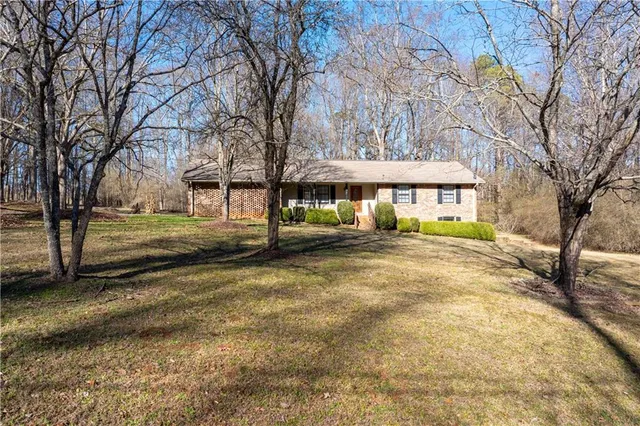 a view of a house with a yard and trees