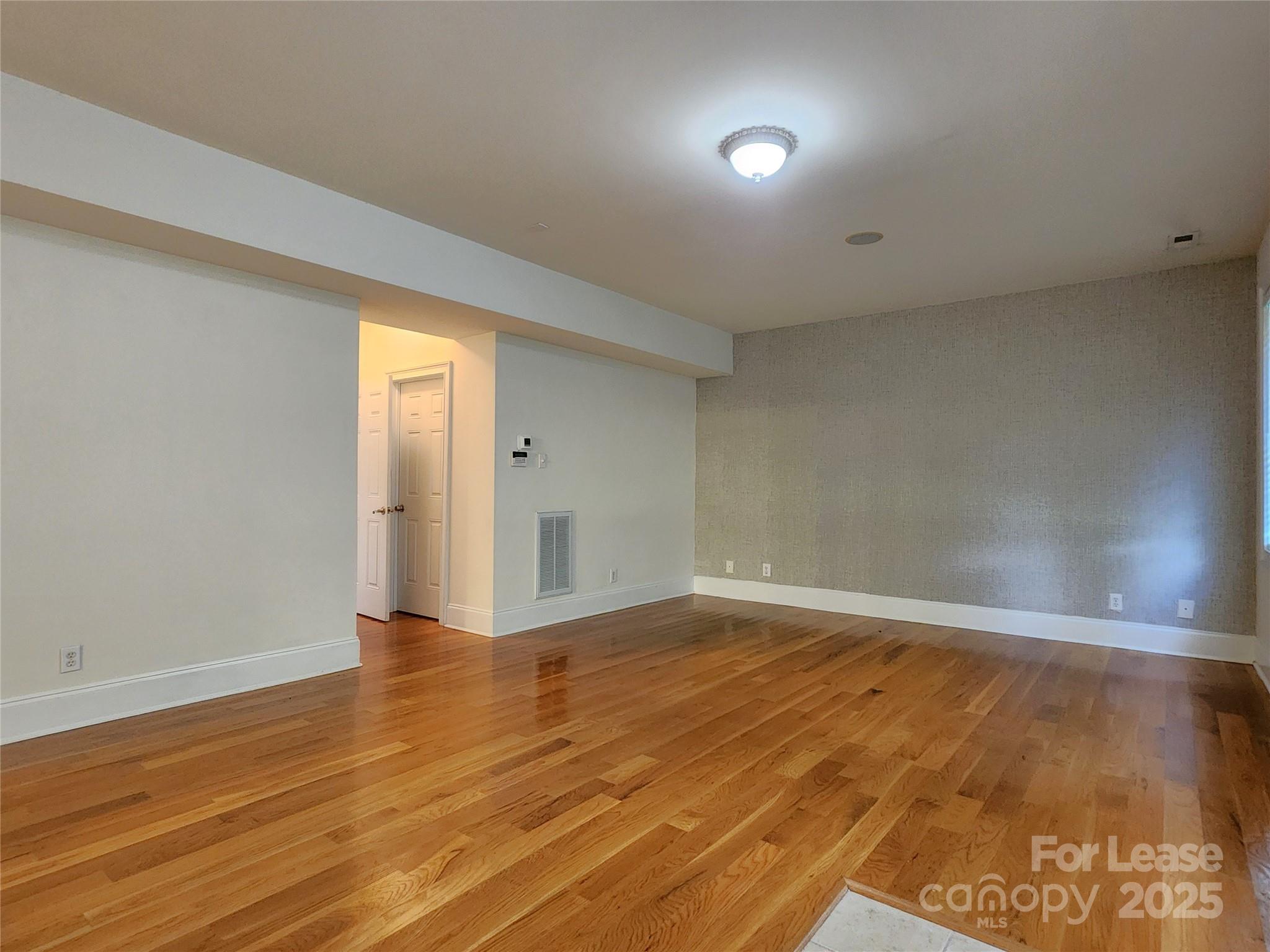 5524 Strabane Drive Matthews, NC 28104 - Photo 17 of 41 an empty room with wooden floor and windows
