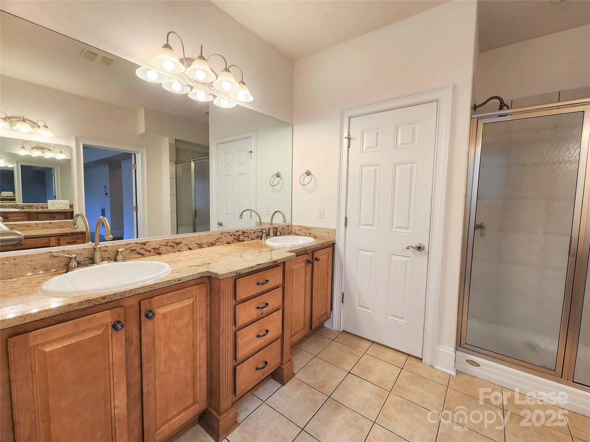 5524 Strabane Drive Matthews, NC 28104 - Photo 20 of 41 a bathroom with a granite countertop sink a mirror and a shower