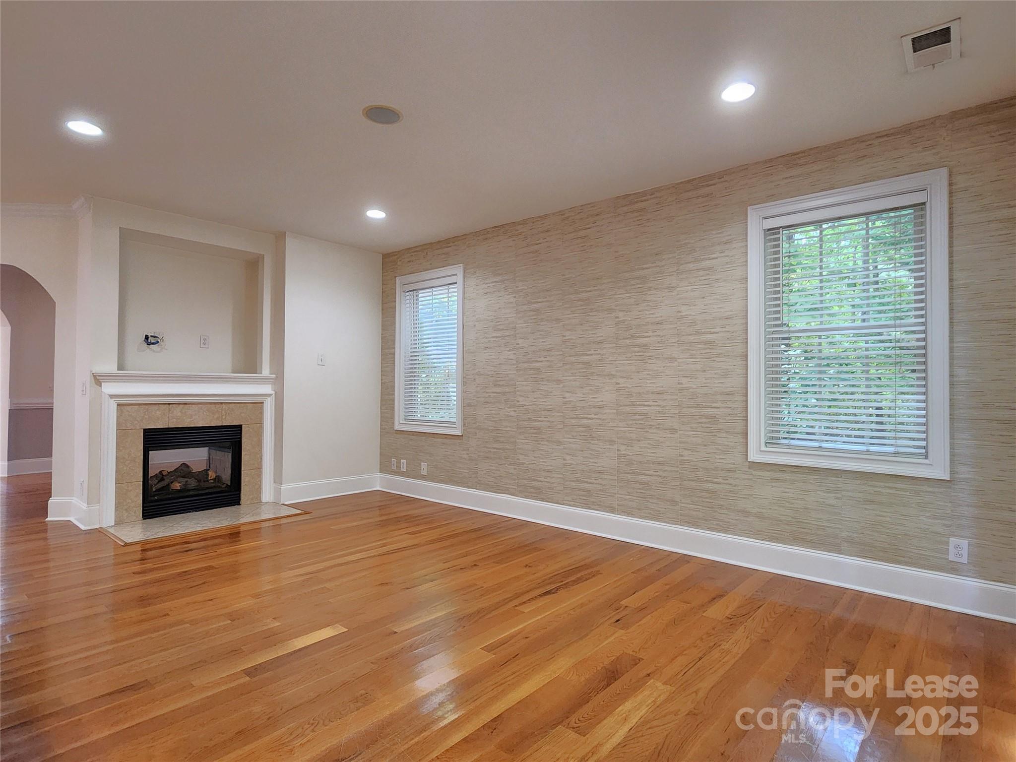 5524 Strabane Drive Matthews, NC 28104 - Photo 8 of 41 an empty room with wooden floor fireplace and windows