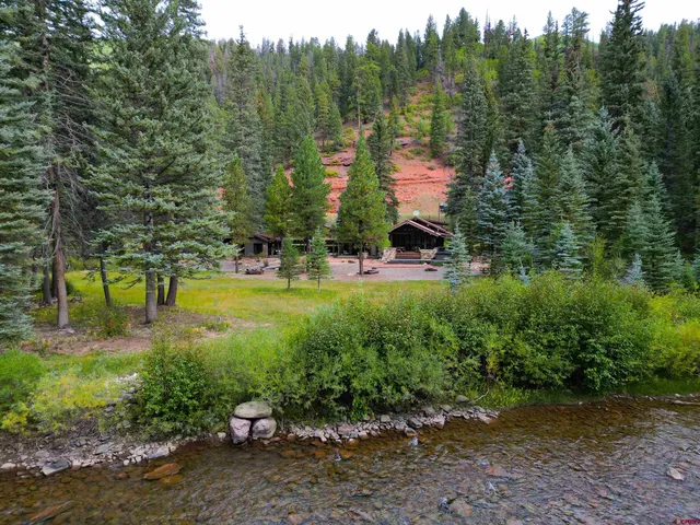 a very nice looking living room with a large window and dining table
