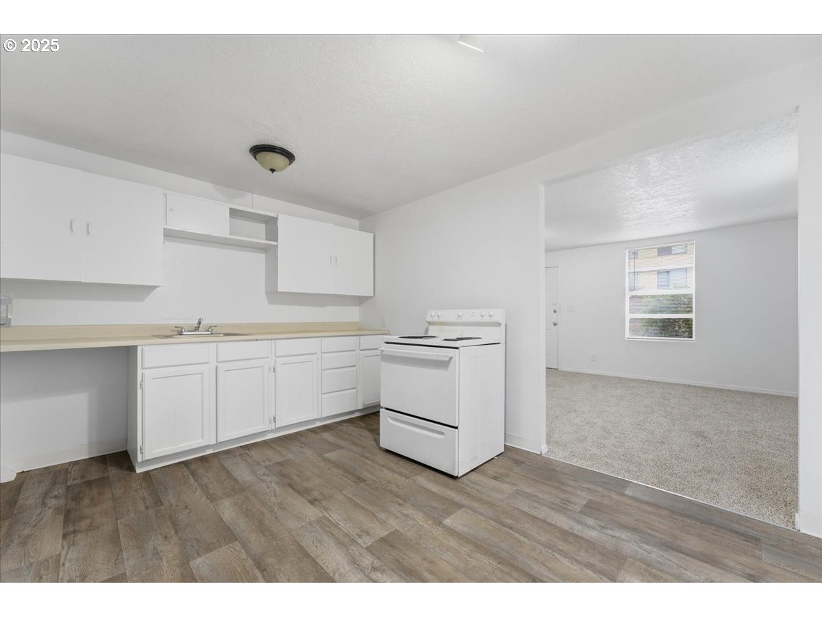 18427 Southeast Yamhill Street Gresham, OR 97233 - Photo 18 of 39 a kitchen with white cabinets and wooden floor