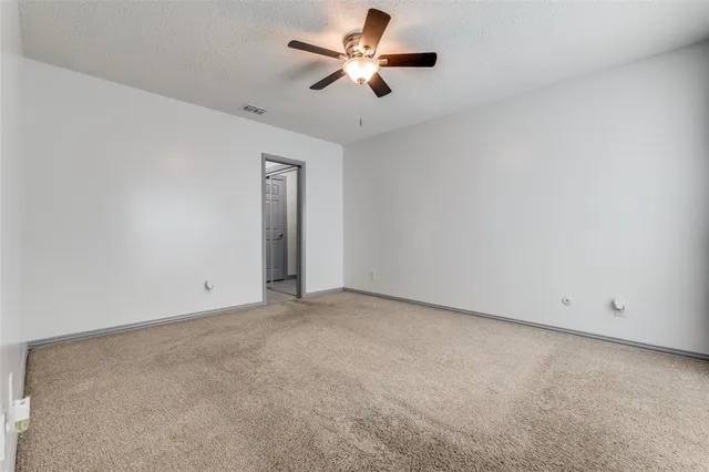 an empty room with chandelier fan