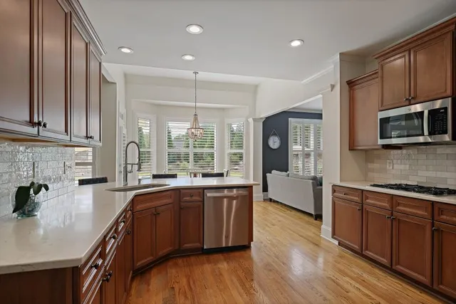a large kitchen with stainless steel appliances granite countertop a lot of counter space and wooden floor