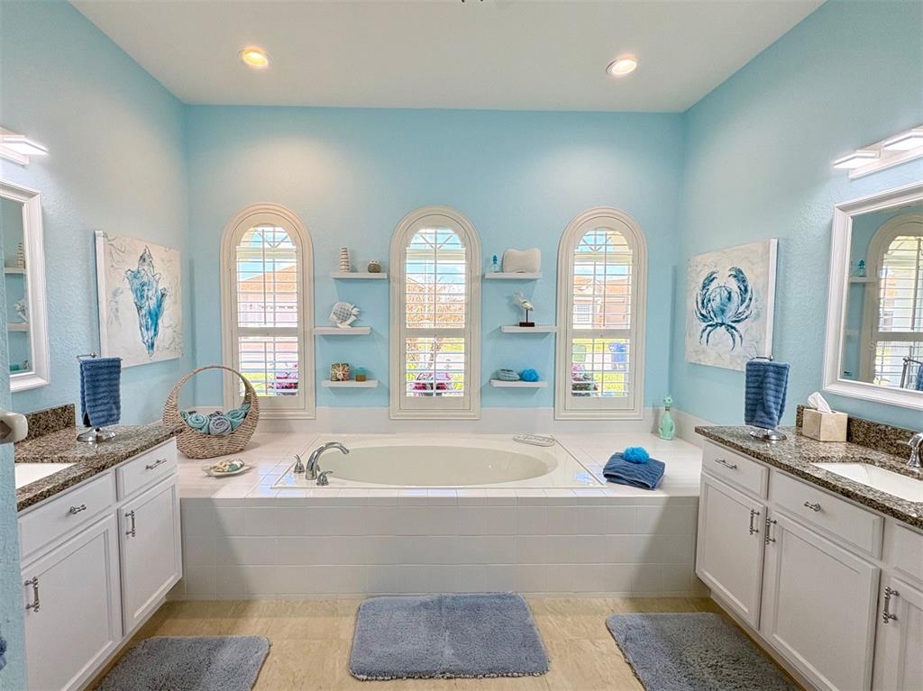 6261 Pinehurst Loop Winter Haven, FL 33884 - Photo 52 of 76 a spacious bathroom with double vanity a large mirror a bathtub and a shower