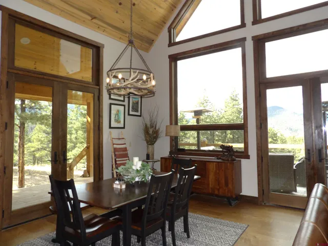 a dining room with furniture a chandelier and wooden floor