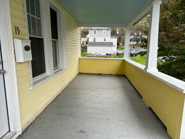 a view of a kitchen with a fridge and wooden floor