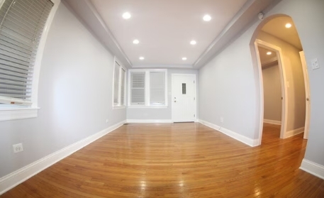 2435 North Rutherford Avenue Chicago, IL 60707 - Photo 3 of 5 an empty room with wooden floor and windows