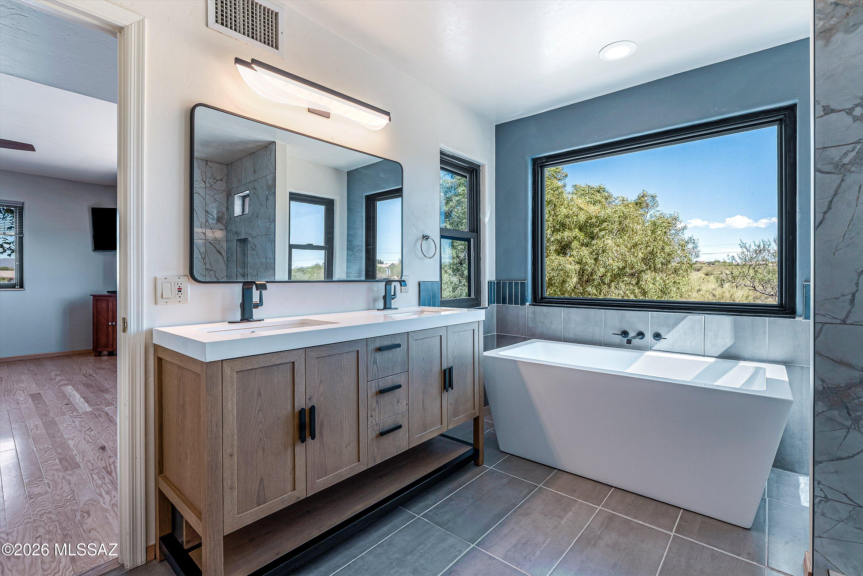 100 North Eastern Slope Loop Tucson, AZ 85748 - Photo 20 of 37 The beautifully remodeled primary bathroom invites you to relax and appreciate the beautiful views.