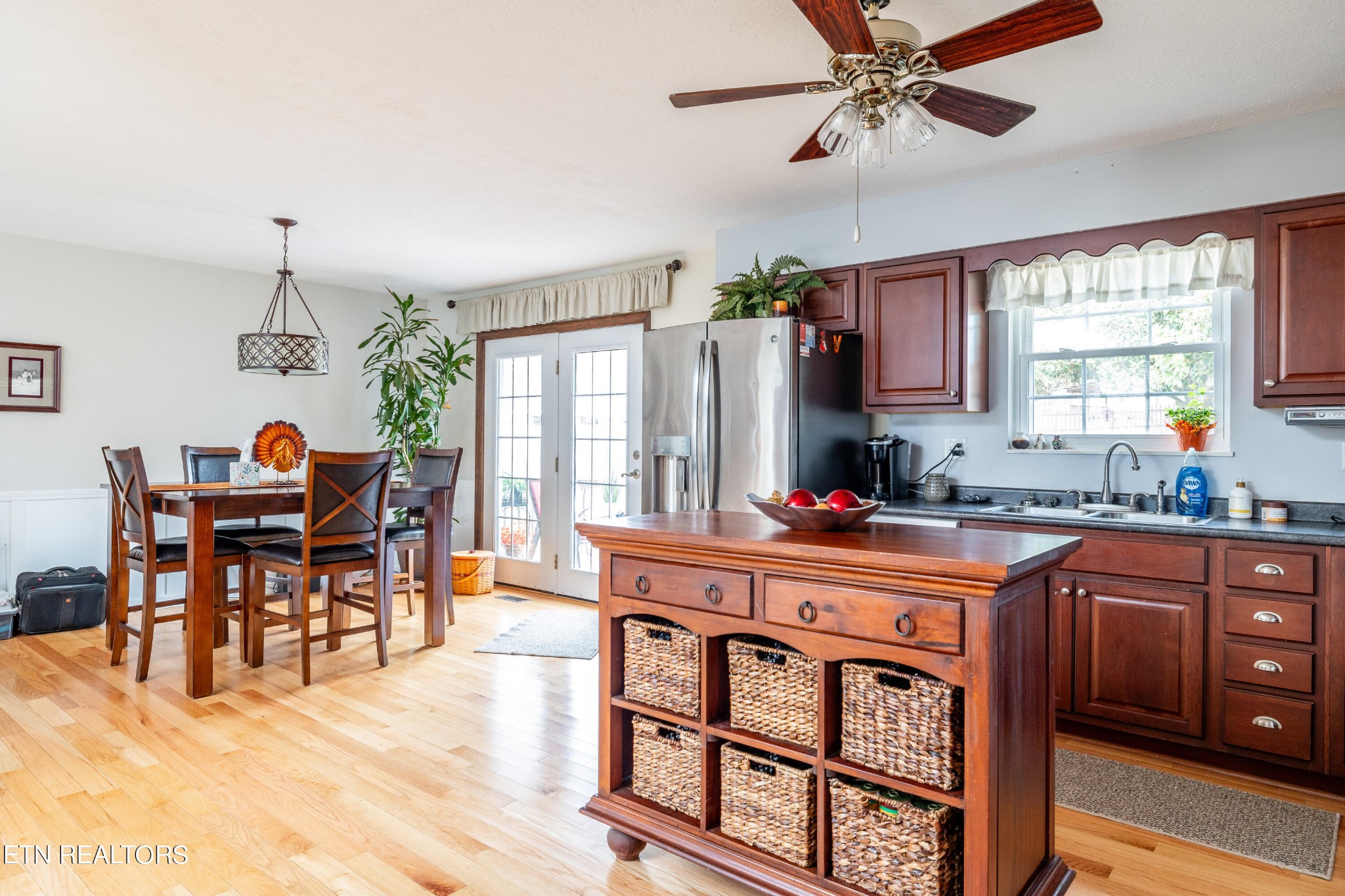 625 Riverbend Road Clinton, TN 37716 - Photo 17 of 45 a kitchen with stainless steel appliances granite countertop a stove top oven a refrigerator a dining table and chairs with wooden floor