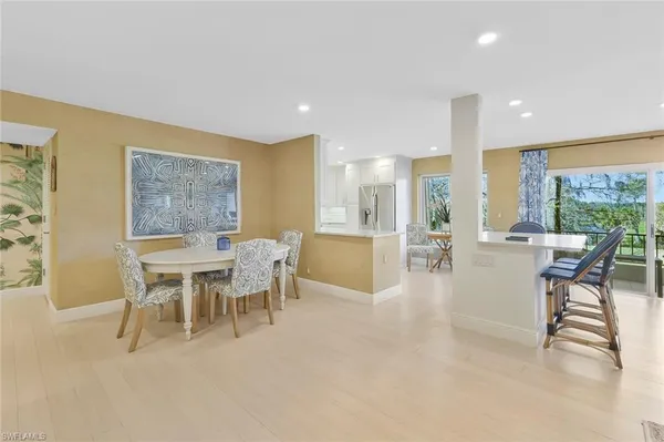 a dining room with furniture and a floor to ceiling window