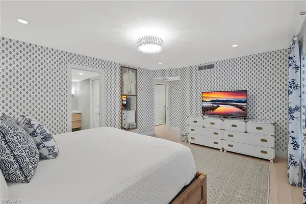a bedroom with a bed and a painting on the wall