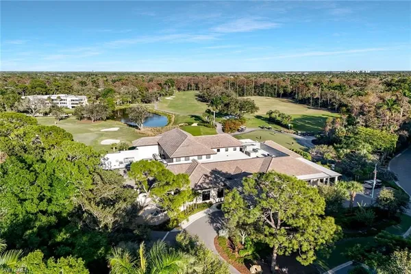 an aerial view of residential houses with outdoor space and trees