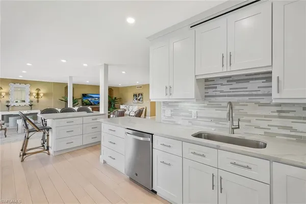 a kitchen with white cabinets white appliances and sink