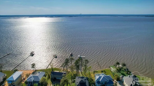 an aerial view of a house with a yard and lake view