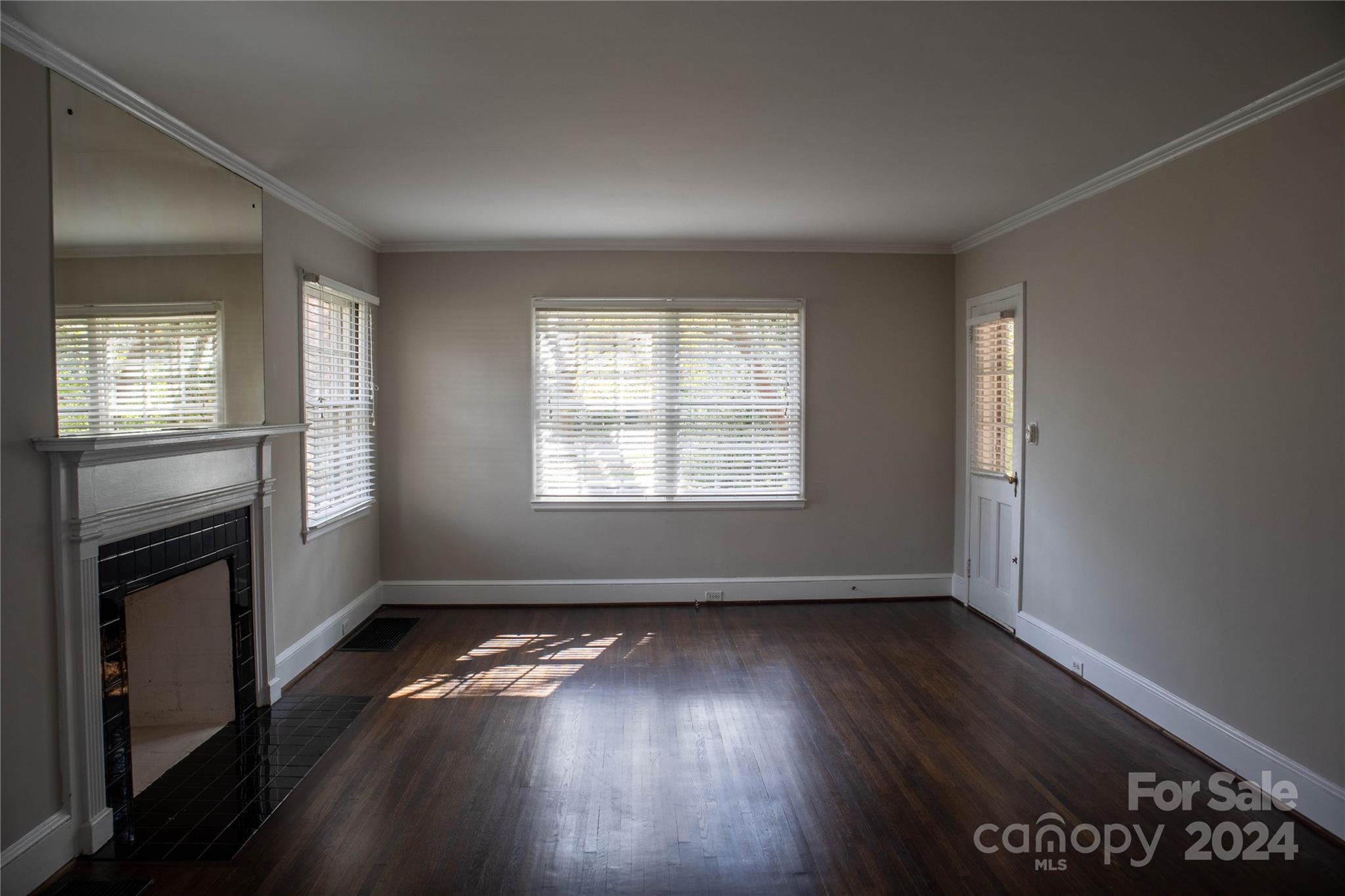 2932 Park Road Charlotte, NC 28209 - Photo 2 of 17 an empty room with wooden floor fireplace and windows