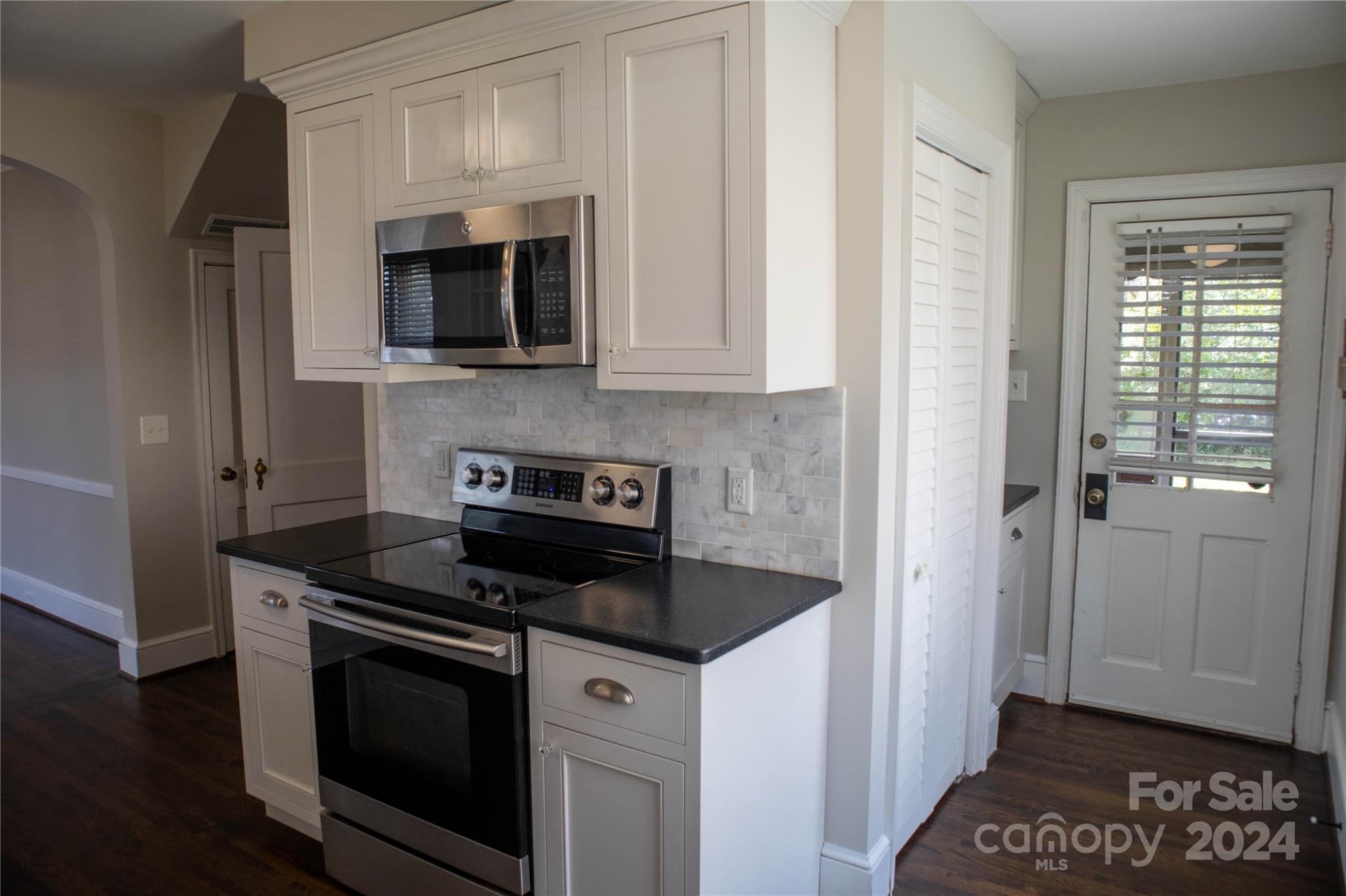 2932 Park Road Charlotte, NC 28209 - Photo 7 of 17 a kitchen with stainless steel appliances granite countertop a stove a microwave and a refrigerator