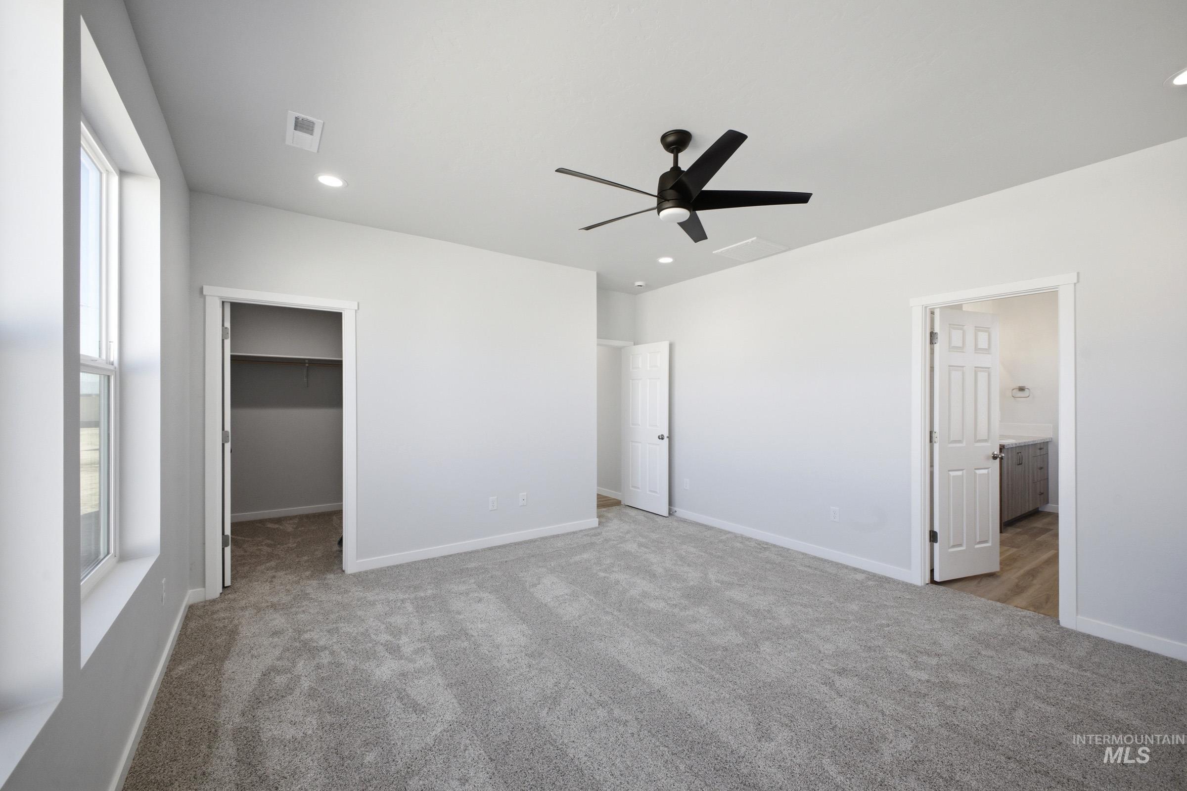 13633 Redway Court Caldwell, ID 83607 - Photo 23 of 29 Unfurnished bedroom with a spacious closet, light colored carpet, a ceiling fan, recessed lighting, and ensuite bath