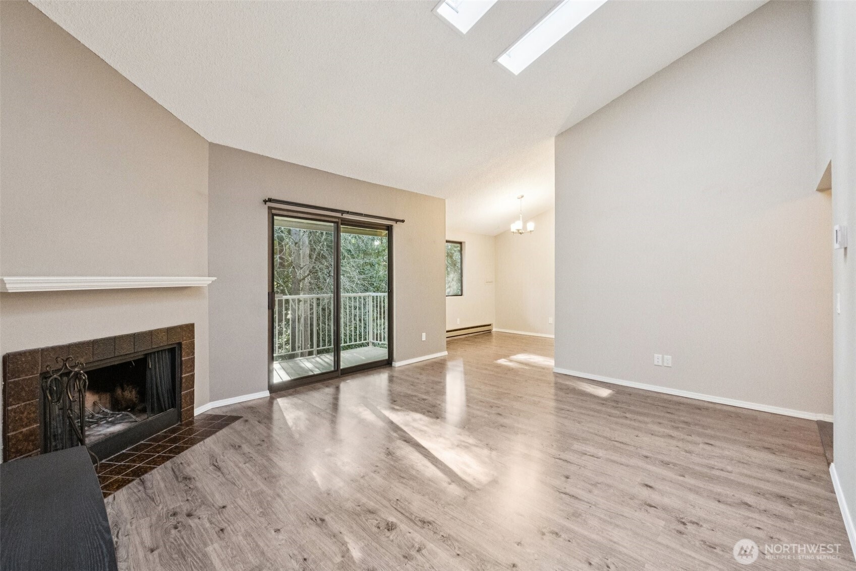 5502 220th Street Southwest, Unit D201 Mountlake Terrace, WA 98043 - Photo 5 of 19 an empty room with wooden floor fireplace and windows