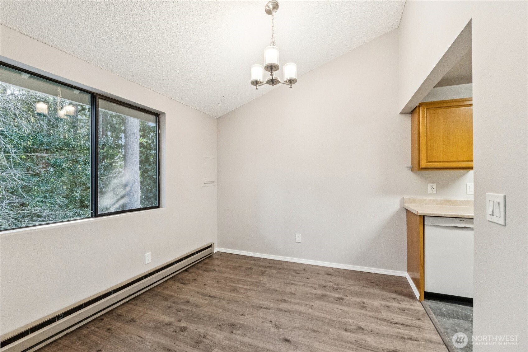 5502 220th Street Southwest, Unit D201 Mountlake Terrace, WA 98043 - Photo 6 of 19 a view of an empty room with a window and wooden floor