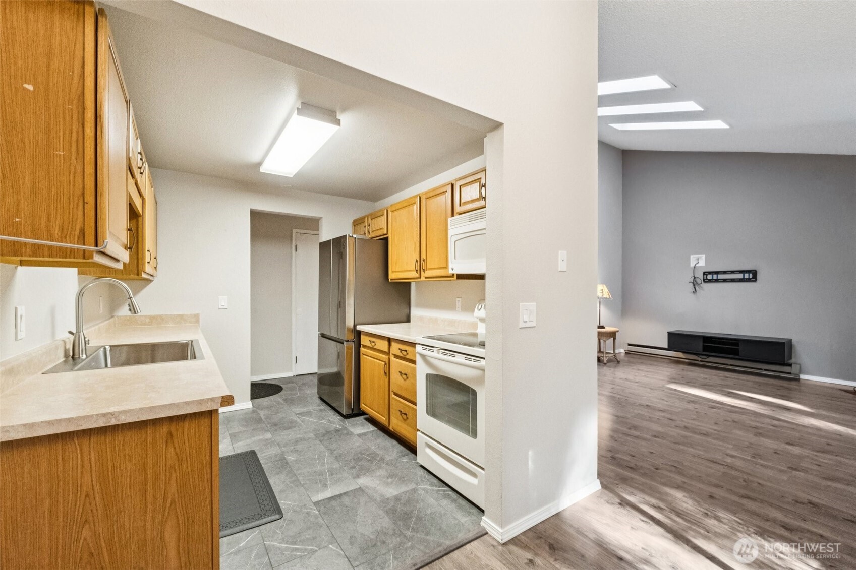5502 220th Street Southwest, Unit D201 Mountlake Terrace, WA 98043 - Photo 7 of 19 a kitchen with stainless steel appliances granite countertop a sink stove and refrigerator