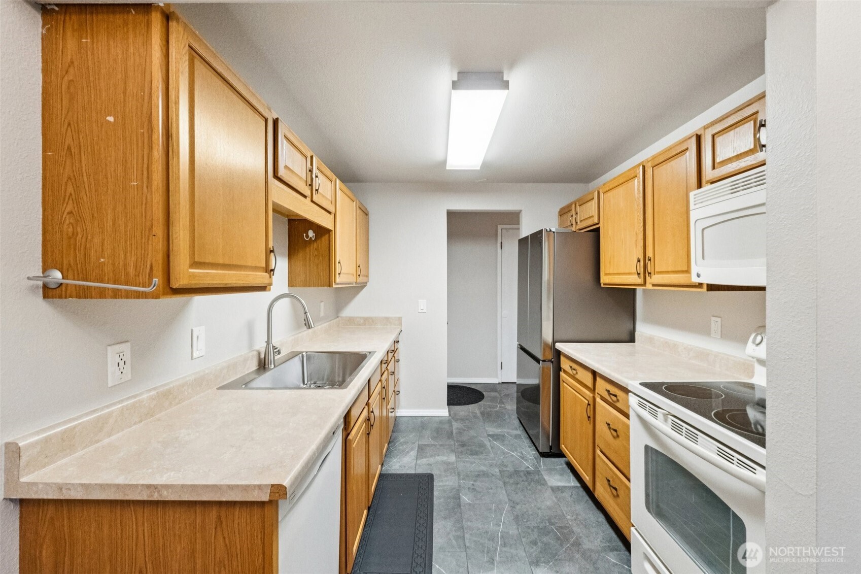 5502 220th Street Southwest, Unit D201 Mountlake Terrace, WA 98043 - Photo 8 of 19 a kitchen with a sink stove and cabinets