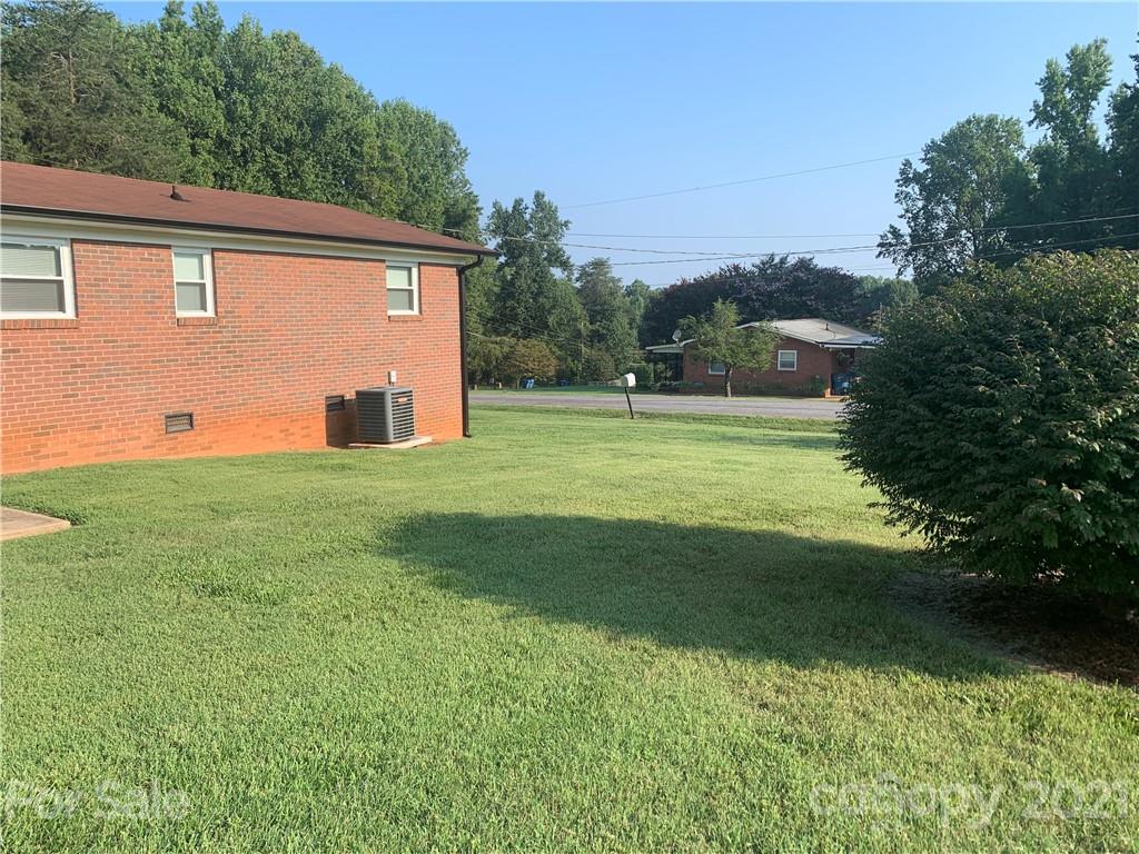 1900 Crestview Drive Newton, NC 28658 - Photo 12 of 13 a view of a backyard with grass and a large tree
