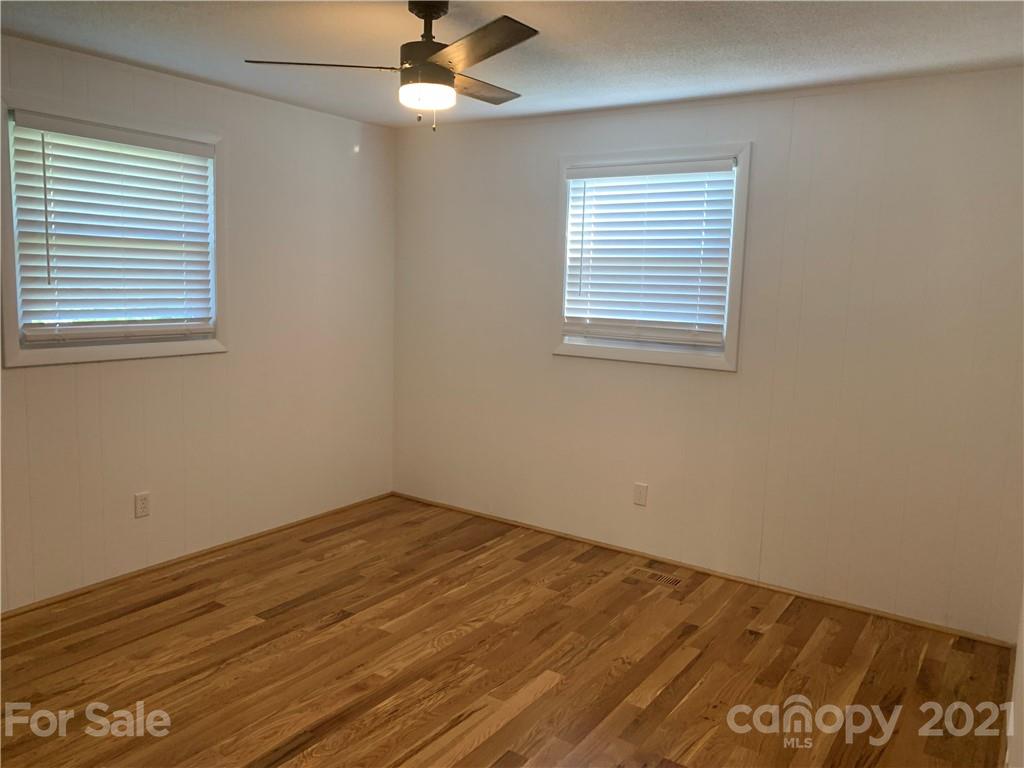 1900 Crestview Drive Newton, NC 28658 - Photo 6 of 13 an empty room with wooden floor fan and windows