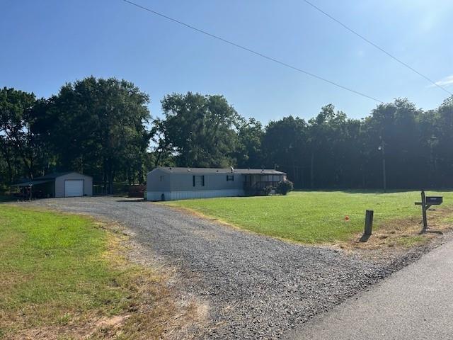 2273 Poole Road Elm Grove, LA 71051 - Photo 1 of 1 View of front of property featuring a detached garage, a front yard, gravel driveway, and an outdoor structure
