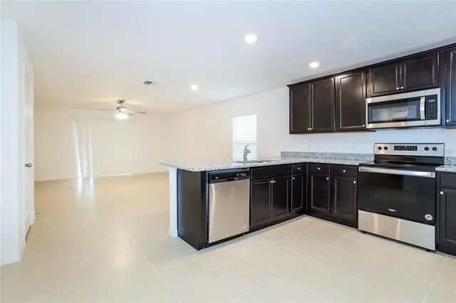 a kitchen with stainless steel appliances kitchen island granite countertop a stove a sink and a microwave