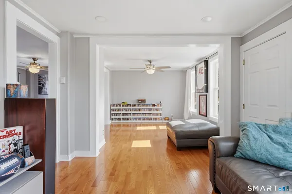 a view of a livingroom with wooden floor and a ceiling fan